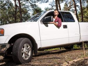 Auto insurance coverage in Bay City with a man driving a white pickup truck