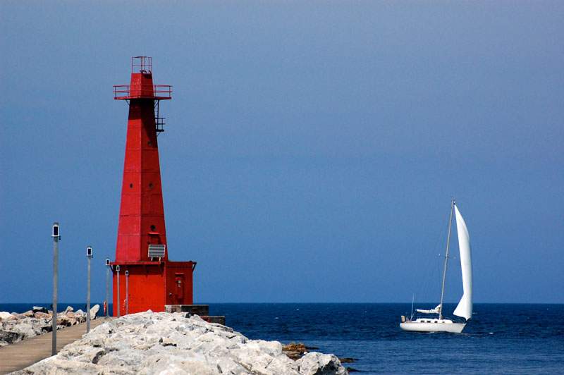 Lighthouse and boat on Lake Michigan covered by Boat Insurance in Saginaw, MI